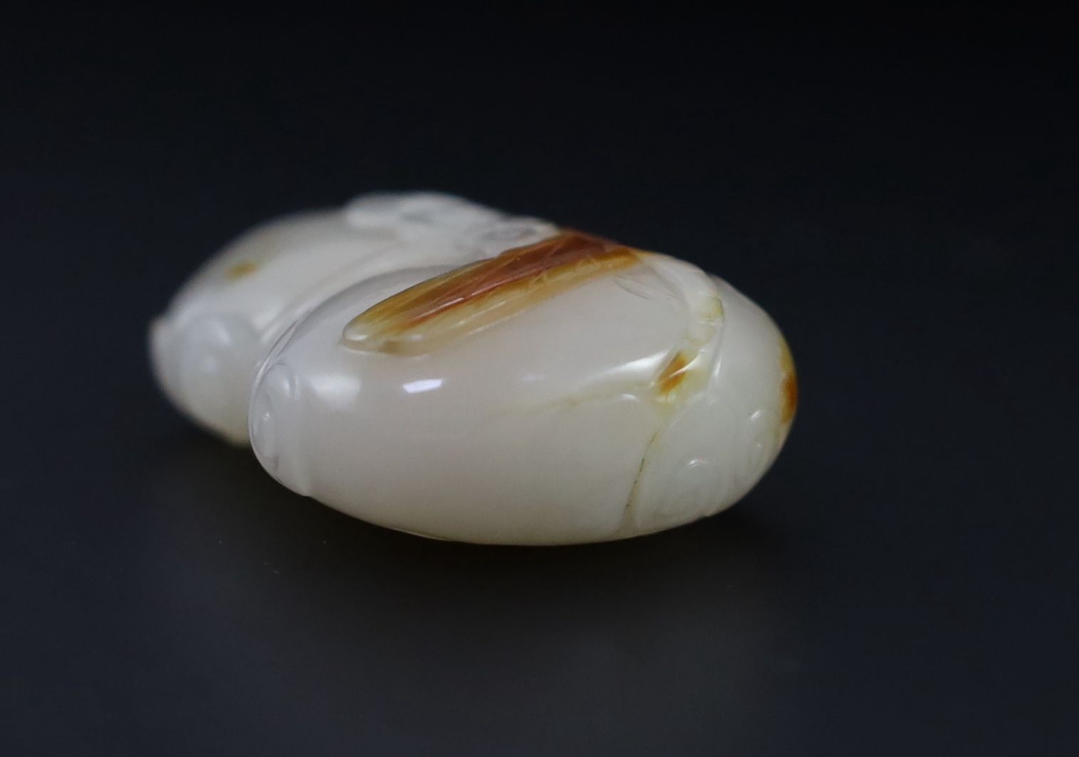 A Chinese white and russet jade snuff bottle, 19th century, 4.9 cm high excluding stopper